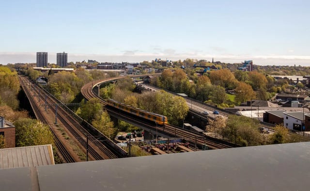 Train on bridge above railway tracks exterior at The Bridge Phase II in Newcastle Upon Tyne Student Accommodation