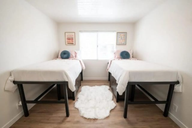 Two beds white rug wall art bedroom at Cedar Flats Student Housing in St. George Student Accommodation