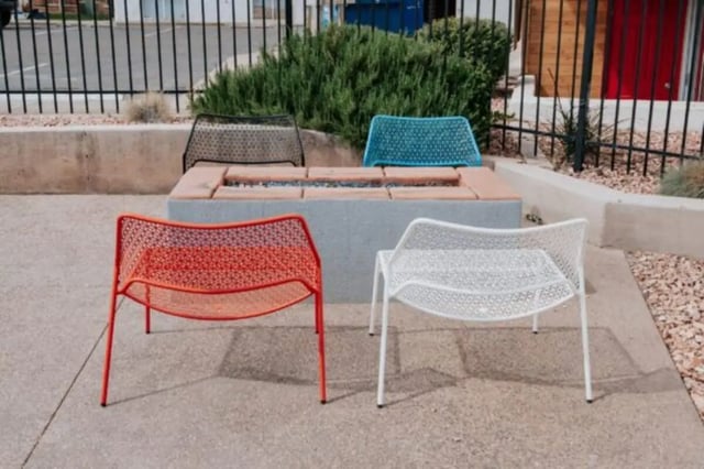 Four colorful mesh chairs surrounding fire pit outdoor area at Cedar Flats Student Housing in St. George Student Accommodation