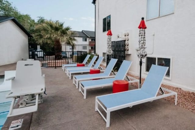 Pool lift lounge chairs red tables umbrellas exterior at Cedar Flats Student Housing in St. George Student Accommodation