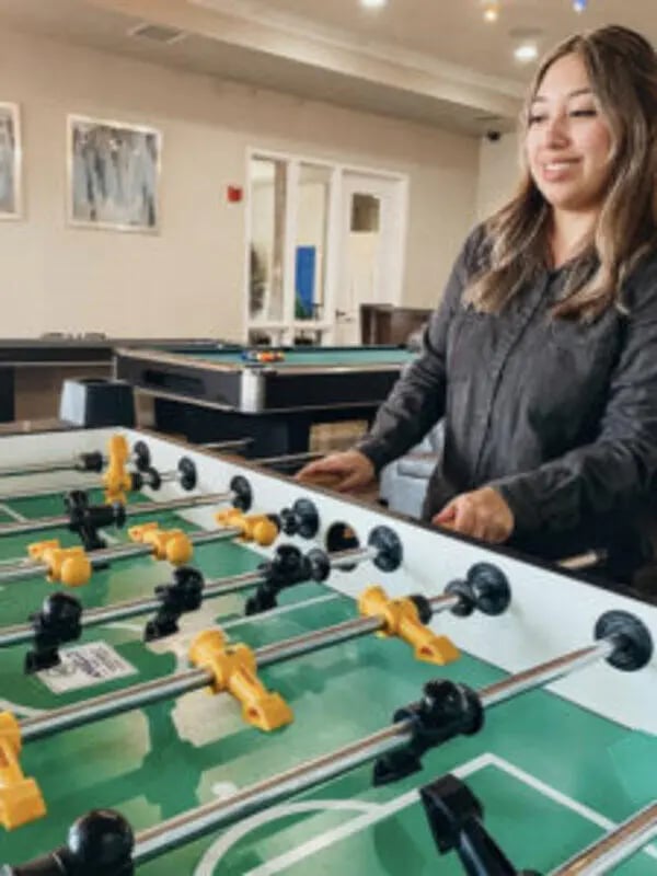 Foosball table with pool table in background game room at Angelo Place Apartments in San Angelo Student Accommodation