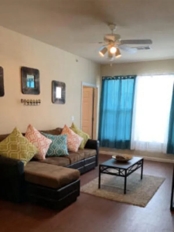 Sectional sofa with patterned pillows coffee table rug living room at Angelo Place Apartments in San Angelo Student Accommodation