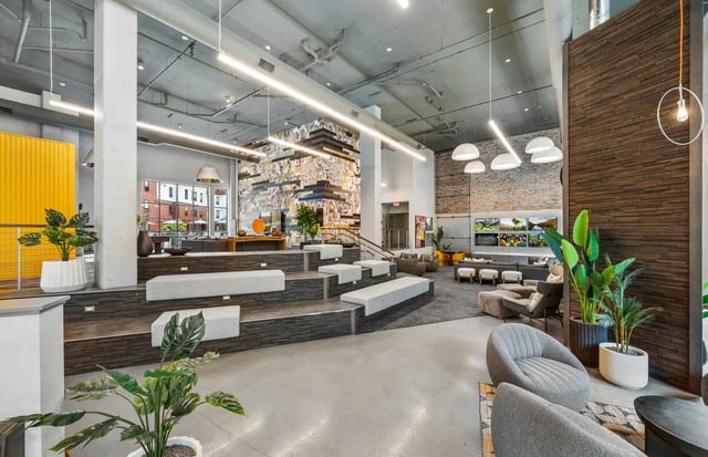 Tiered seating with lounge chairs and plants common area at The Yard in Ann Arbor Student Accommodation