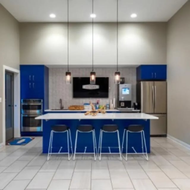 Blue island with stools and appliances kitchen at Eastgate Apartments in Waco Student Accommodation