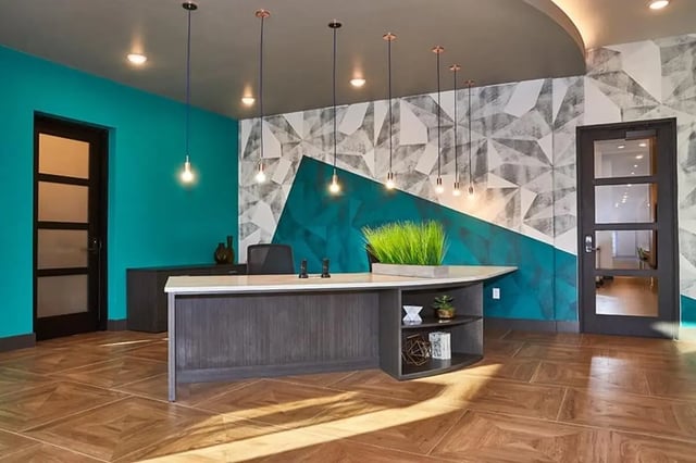 Reception desk with plants and geometric wallpaper lobby at 848 Mitchell in Arlington Student Accommodation
