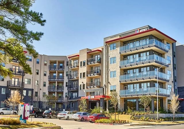 Apartment building with balconies cars and trees exterior at 848 Mitchell in Arlington Student Accommodation