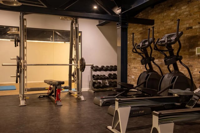 Gym equipment with weight rack and elliptical machines. Gym at The Bridge Phase II in Newcastle Upon Tyne Student Accommodation