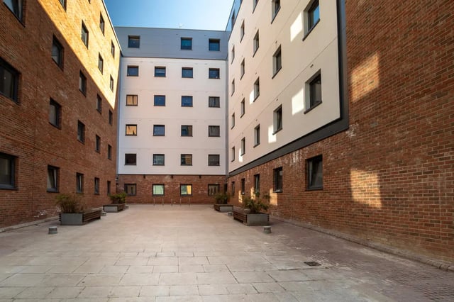 Courtyard with brick buildings benches and bike racks exterior at The Bridge Phase II in Newcastle Upon Tyne Student Accommodation