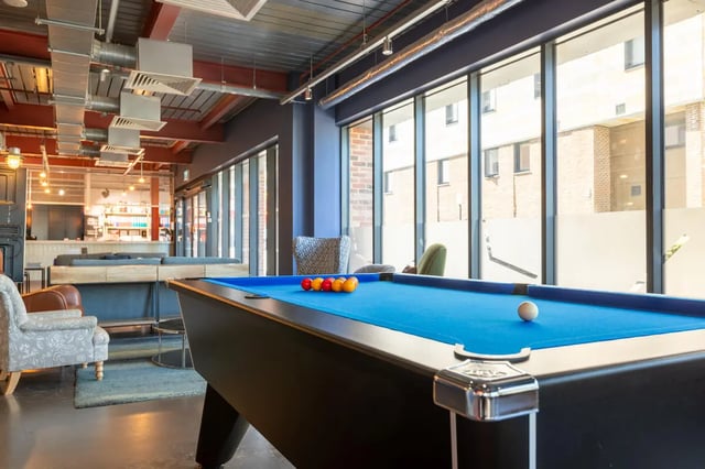 Pool table with balls sofas and counter common area at The Bridge Phase II in Newcastle Upon Tyne Student Accommodation