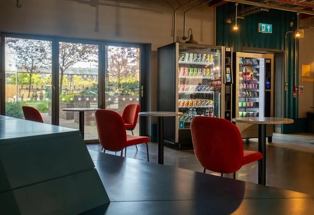 Vending machines and red chairs communal area at The Bridge Phase II in Newcastle Upon Tyne Student Accommodation
