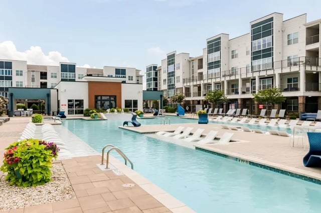 Swimming pool with loungers and buildings exterior at URSA in Waco Student Accommodation