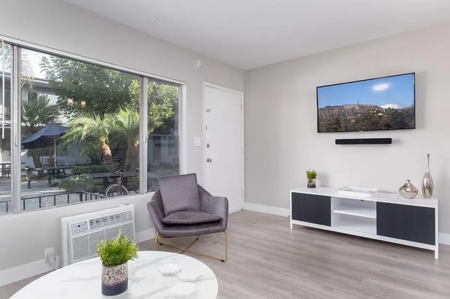 Armchair coffee table TV and exterior view living room at USC Student Housing: Heritage 2353 in Los Angeles Student Accommodation