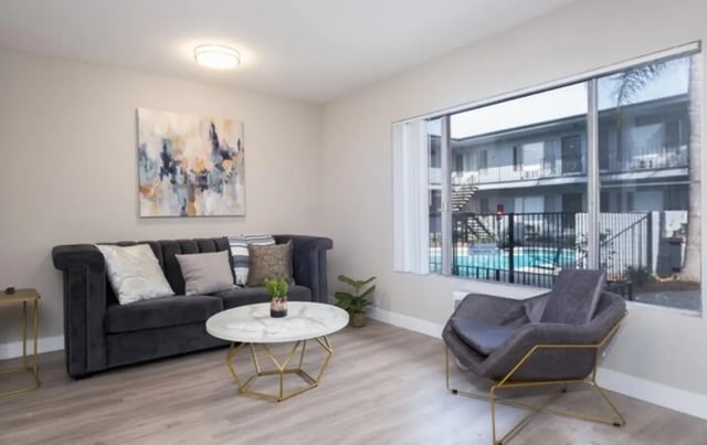 Dark sofa coffee table art chair swimming pool living room at USC Student Housing: Heritage 2353 in Los Angeles Student Accommodation