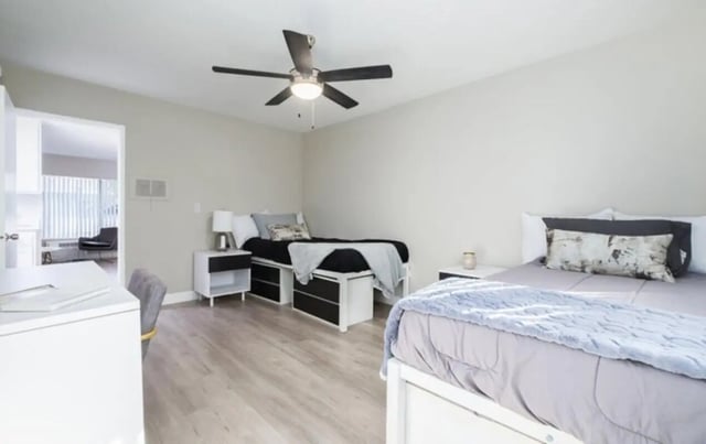 Two beds ceiling fan desk and chairs bedroom at USC Student Housing: Heritage 2353 in Los Angeles Student Accommodation