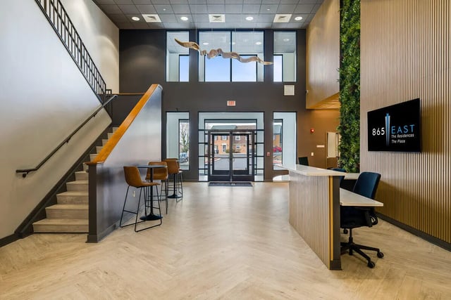 Modern reception desk with chairs and staircase area lobby at 865 East in Harrisonburg Student Accommodation