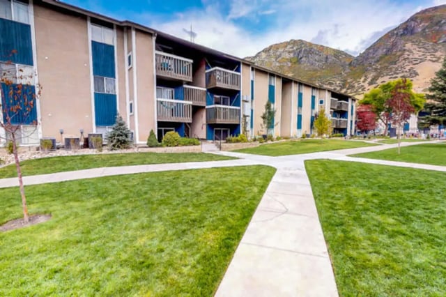 Apartment building with balconies green lawn pathways exterior at Centennial Apartments in Provo Student Accommodation