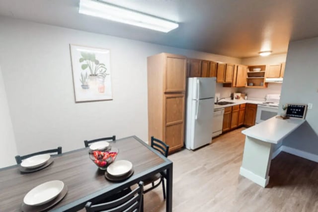 Dining table kitchen cabinets refrigerator welcome sign kitchen at Centennial Apartments in Provo Student Accommodation