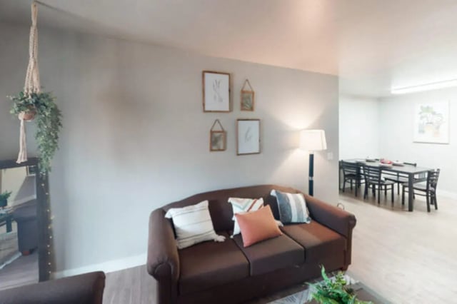 Brown couch with pillows dining table with chairs living room at Centennial Apartments in Provo Student Accommodation