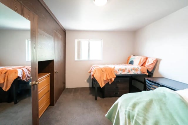 Two beds wooden dresser closet bedroom area at Centennial Apartments in Provo Student Accommodation