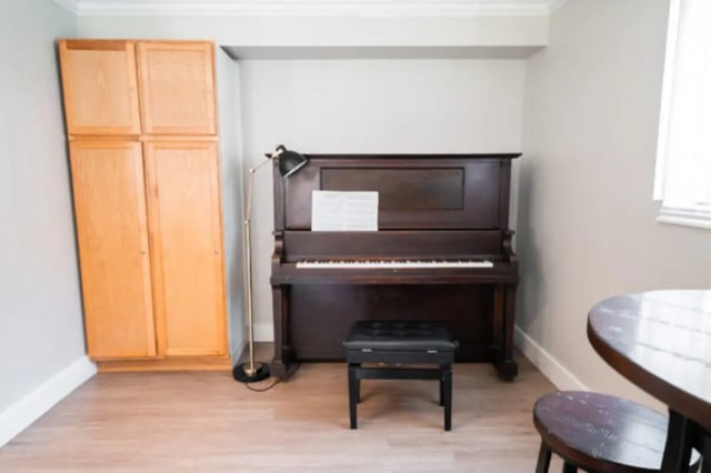 Upright piano sheet music floor lamp cabinet sitting area at Centennial Apartments in Provo Student Accommodation