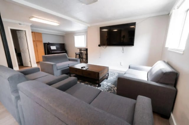 Gray sofas coffee table TV piano living room at Centennial Apartments in Provo Student Accommodation