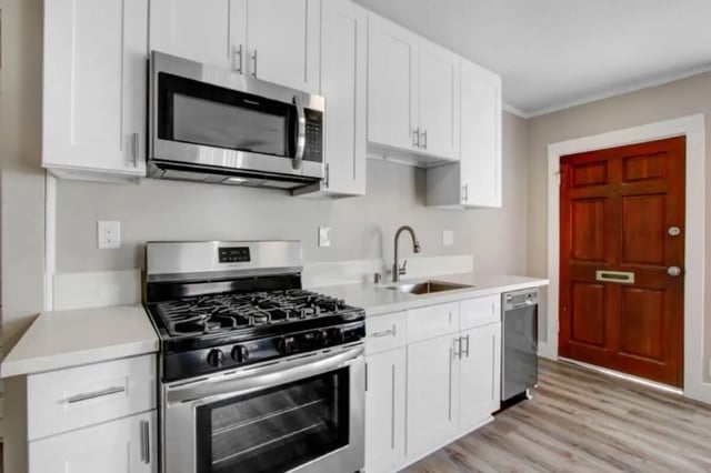 Stainless steel appliances white cabinets wooden door kitchen at USC Student Housing: Heritage 631 in Los Angeles Student Accommodation