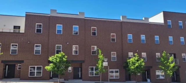 Brick building with multiple windows green trees exterior at 9 North Apartments in Bloomington Student Accommodation