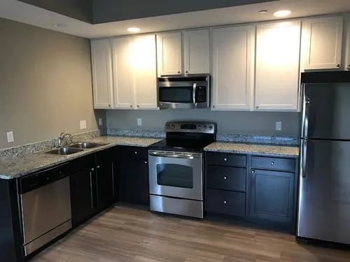 Stainless steel appliances, dark cabinets, white uppers kitchen at 9 North Apartments in Bloomington Student Accommodation