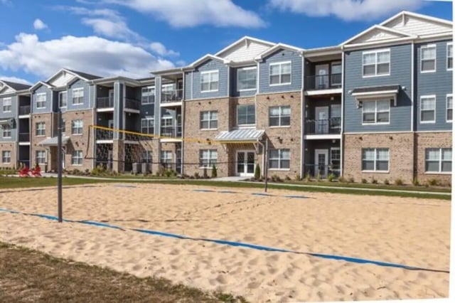 Sand volleyball court next to apartment building exterior at The Lodge at Allendale in Allendale Student Accommodation