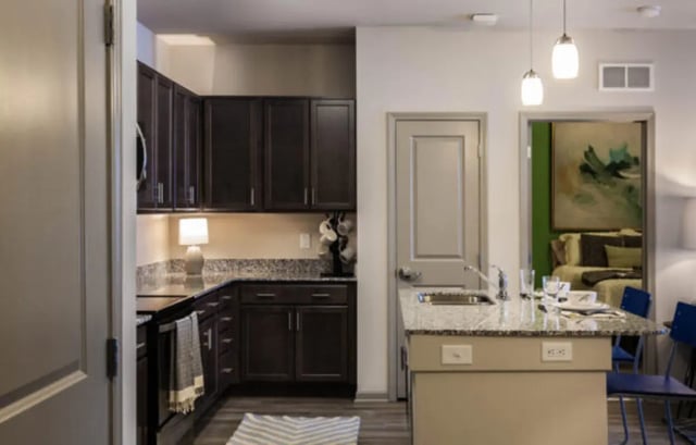 Dark cabinets granite counters island seating kitchen at The Lodge at Allendale in Allendale Student Accommodation