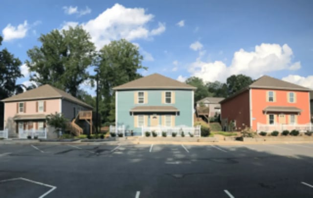 Three colorful student houses with parking lot exterior at Victory Villages in Winston-Salem Student Accommodation