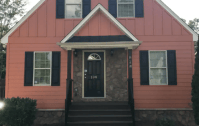 Pink house with black shutters and door exterior at Victory Villages in Winston-Salem Student Accommodation