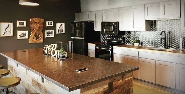 Kitchen island with artwork and appliances kitchen at Eight Thirty Water Tower Apartments in Big Rapids Student Accommodation