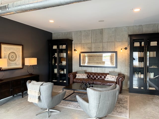 Brown sofa two chairs black cabinets artwork living room at Eight Thirty Water Tower Apartments in Big Rapids Student Accommodation