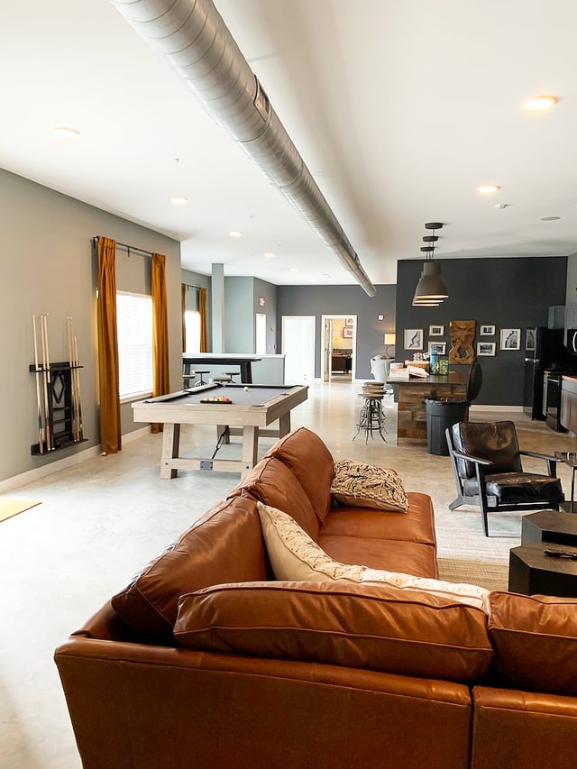 Leather sofa pool table pool cues living room at Eight Thirty Water Tower Apartments in Big Rapids Student Accommodation