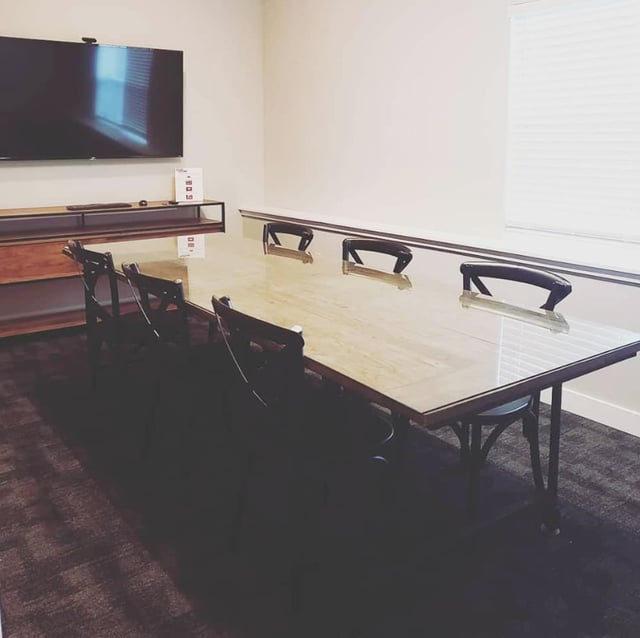 Conference table and chairs with TV study area at Eight Thirty Water Tower Apartments in Big Rapids Student Accommodation