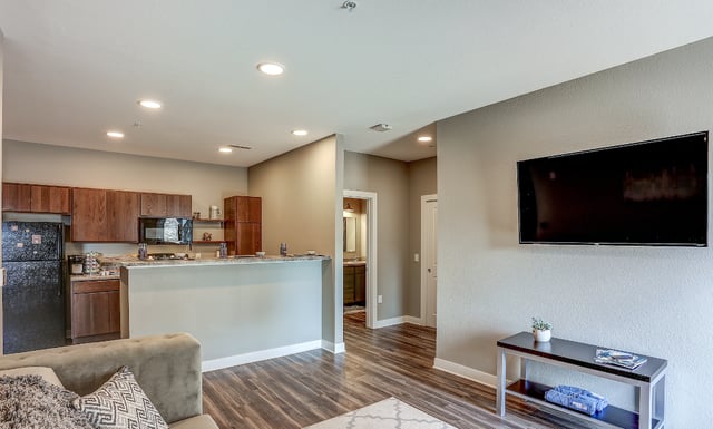 Kitchen living room with couch and TV at Eight Thirty Water Tower Apartments in Big Rapids Student Accommodation