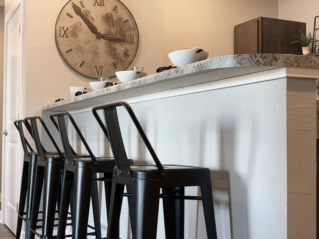 Four black bar stools and serving bowls kitchen bar. at Eight Thirty Water Tower Apartments in Big Rapids Student Accommodation
