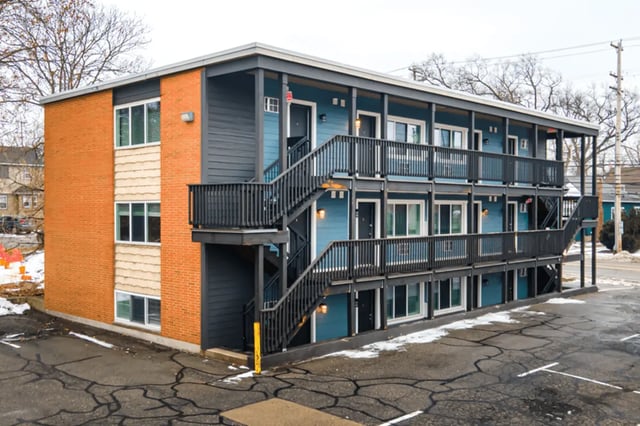 Apartment building exterior with brick and blue siding exterior at Victory at Burcham Woods (731) in East Lansing Student Accommodation