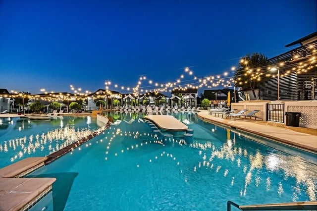 Large pool string lights lounge chairs cabanas Exterior at Cottages at San Marcos in San Marcos Student Accommodation