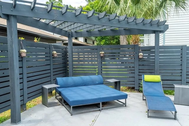 Blue daybed chaise lounges outdoor seating area at Campus Row in Tallahassee Student Accommodation