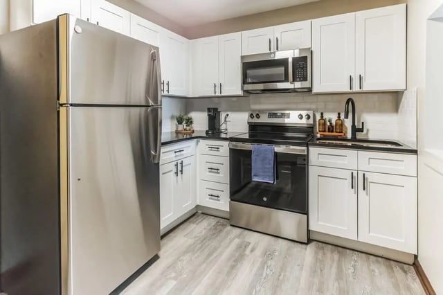 Stainless steel refrigerator white cabinets oven and sink kitchen at Victory on Salisbury in West Lafayette Student Accommodation
