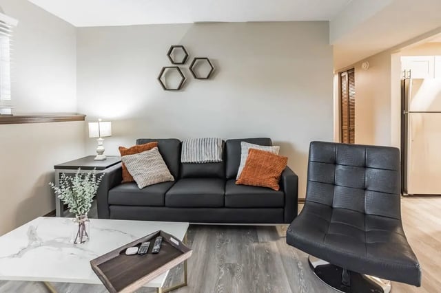 Black sofa with pillows tray and chair living room at Victory on Salisbury in West Lafayette Student Accommodation