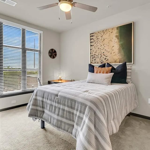 Bed with pillows desk and beach art bedroom at 930 NoMo in Charleston Student Accommodation