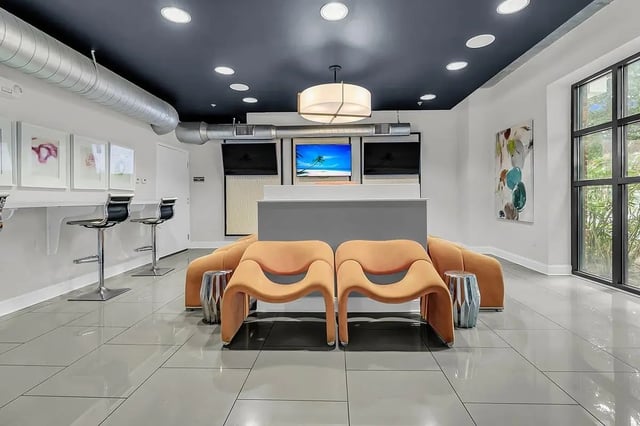Orange chairs silver stools modern lounge area at 930 NoMo in Charleston Student Accommodation
