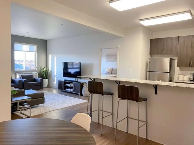 Living room with TV and kitchen bar living room at 940 North in Spokane Student Accommodation