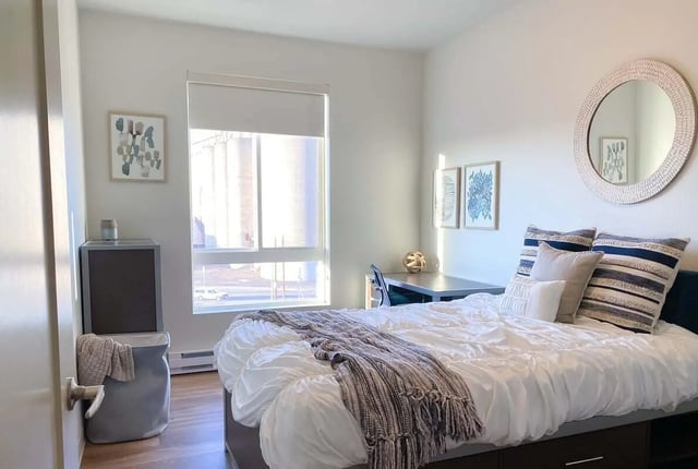 Bed desk laundry hamper artwork mirror bedroom at 940 North in Spokane Student Accommodation