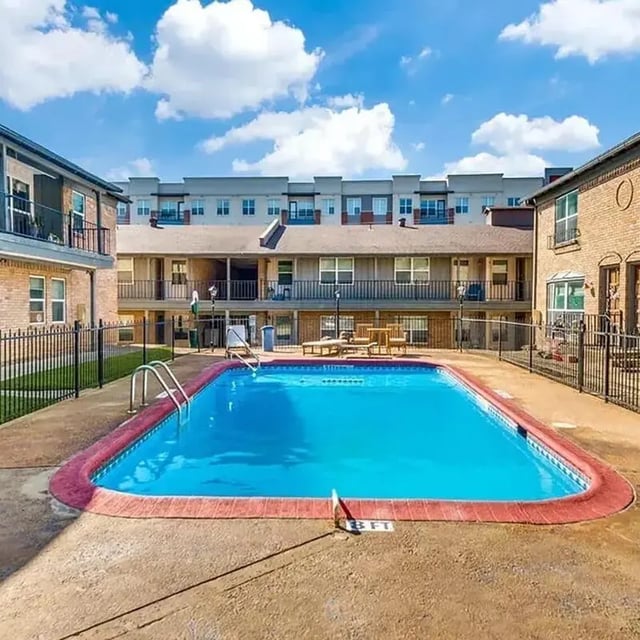 Swimming pool with lounge chairs and buildings Exterior at Denton Student Apartments in Denton Student Accommodation
