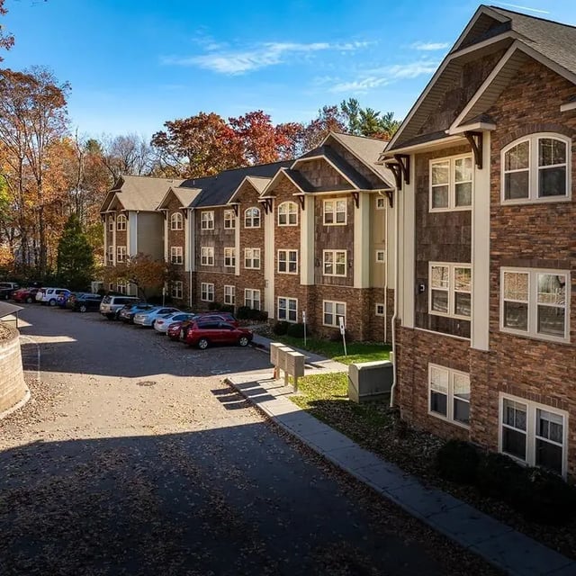 Apartment buildings with stone facade parking lot exterior at Boone Student Living in Boone Student Accommodation