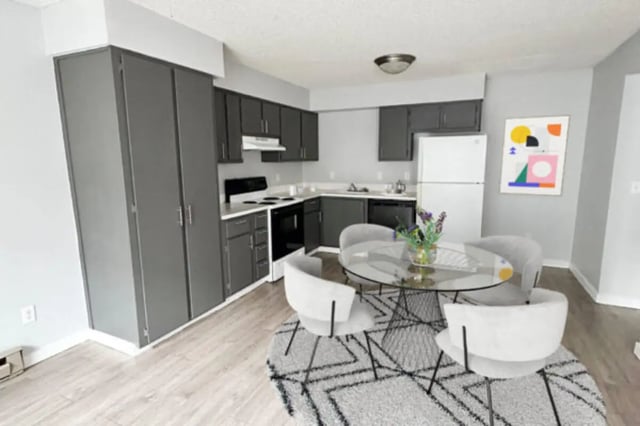 Dark cabinets table chairs abstract art kitchen living room at Cougar Ridge Apartments in Pullman Student Accommodation